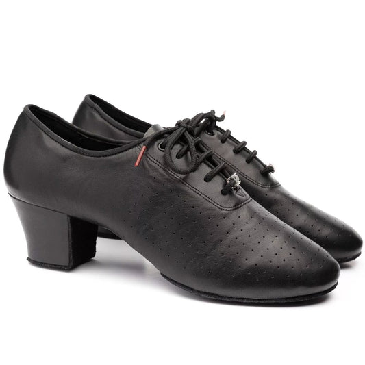 A pair of black leather dance shoes with low block heels, perforated detailing on the toe, and black laces, shown against a plain white background.
